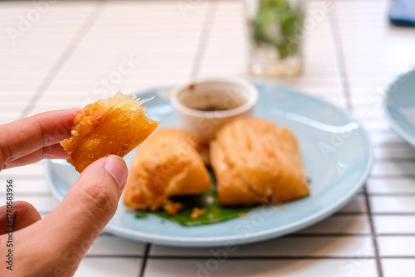 Obraz Golden fried cassava served on a light blue plate with white background. Perfect for restaurant menu design, tropical food promotion, or culinary asia traditional snacks.