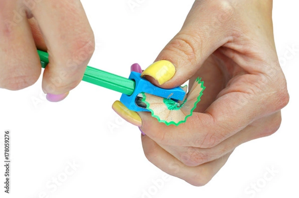 Obraz Hands with sharpener and pencil on an isolated background