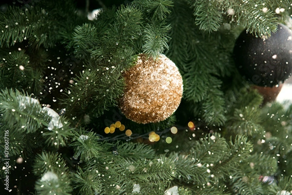 Obraz golden Christmas ball against a Christmas tree outdoors snowflake. Merry Christmas and Happy New Year