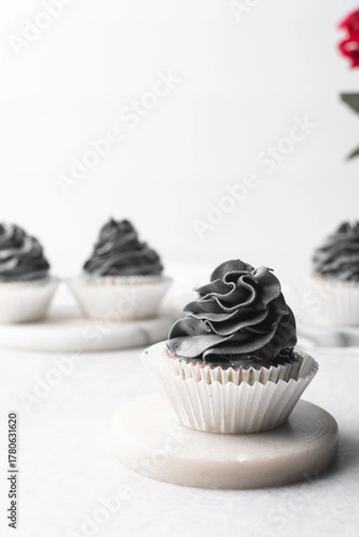 Fototapeta grey frosting on cupcakes with a white background, cupcakes in white liners with tall buttercream swirl, grey buttercream frosted cupcakes on a white background