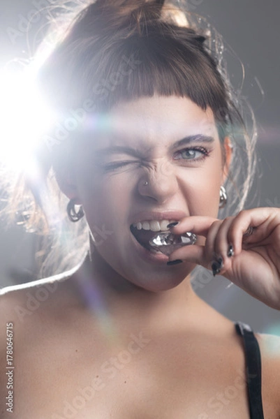 Fototapeta Young Girl Biting a Diamond with a Sassy Wink
