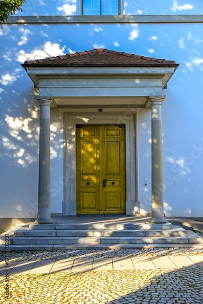 Fototapeta Ornate wooden temple door of the Protestant Church in Uster, featuring carved details and stone arch under natural daylight