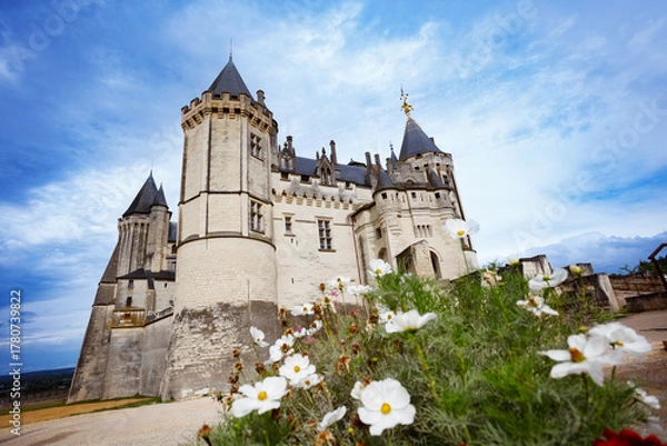Fototapeta Majestic Saumur castle towers set against a vibrant blue sky
