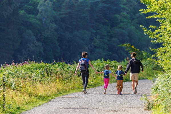 Fototapeta Four people enjoy peaceful nature walk in lush greenery, England
