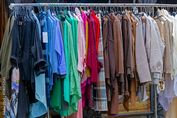 Fototapeta Colorful modern clothes on metal rail sold outside on local market