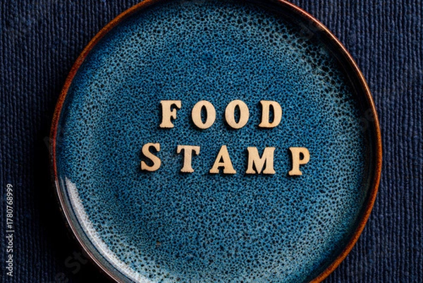 Fototapeta The inscription on the blue plate about food stamp, closeup. The Supplemental Nutrition Assistance Program, known as the Food Stamp Program, is a United States federal government program
