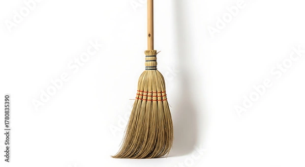 Fototapeta A traditional, natural fiber broom, meticulously crafted for household cleaning and tidying, stands upright, evoking simplicity and the timeless act of maintaining a clean living space