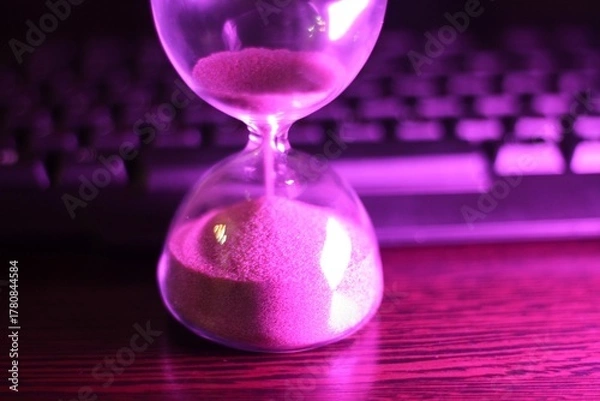 Fototapeta hourglass with the sand and computer keyboard time and work