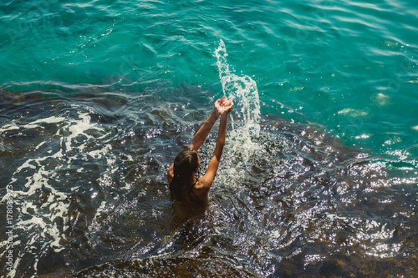 Obraz Beautiful Model Woman with splashes of water in her hands.  Body and skin care. Cleansing and nature and travel concept. Beauty ocean wave.