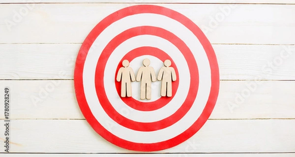 Obraz Three Wooden Human Figures on Red and White Target Circle Symbolizing Audience Focus