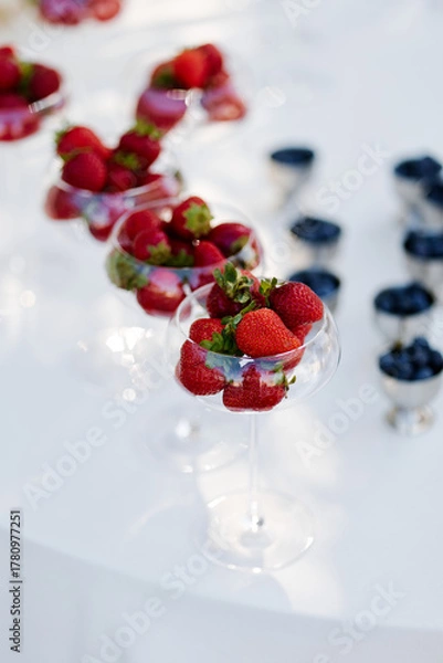 Fototapeta Fresh berries in the bright sun on the dessert table