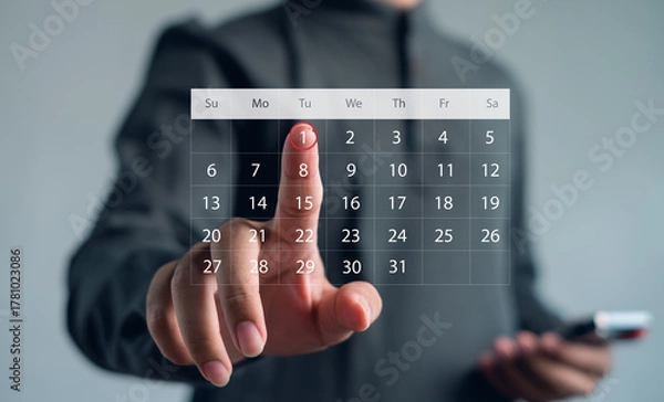 Fototapeta Businessman touching virtual digital calendar interface to schedule and plan work. Concept for productivity, appointment, organization, planning, and modern business technology.