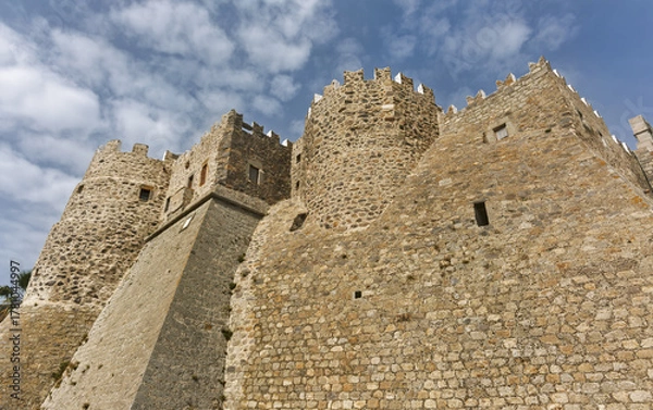 Fototapeta Historic stone fortress with cylindrical tower and crenellated walls surrounding the Monastery of Saint John the Theologian of Patmos, Greece.