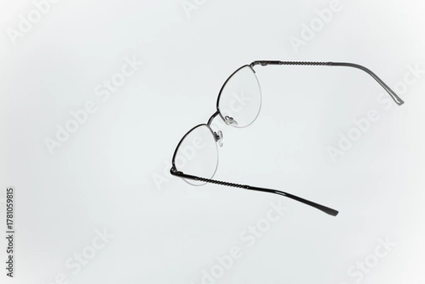 Fototapeta Stylish women’s eyeglasses with thin metal semi-rim frame on white background. Vsion correction concept.