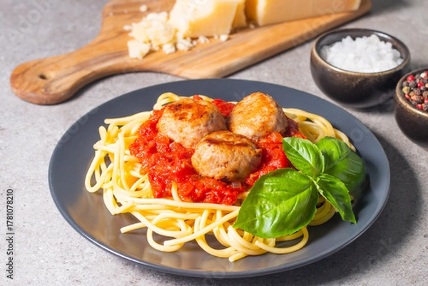 Fototapeta Delicious spaghetti with tasty meatballs in tomato sauce, and basil on background. Restaurant menu.