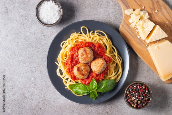 Fototapeta Delicious spaghetti with tasty meatballs in tomato sauce, and basil on background. Restaurant menu.