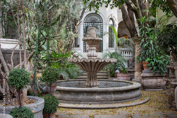 Fototapeta Elegant stone fountain in green courtyard of colonial building in Tlaquepaque, Jalisco
