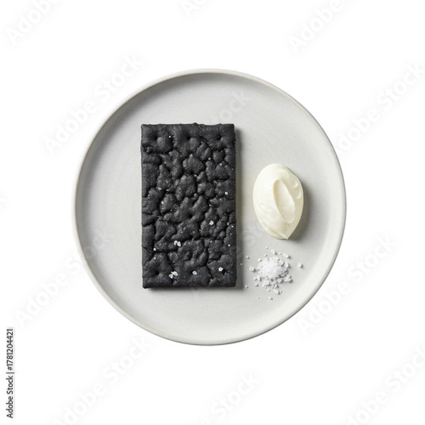 Obraz Flat lay of a gourmet black charcoal cracker with artisan textures, creamy crème fraîche, and sea salt on a white plate, isolated on transparent, high-key lighting. Concept of gourmet food elegance