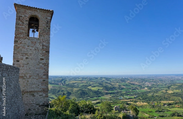 Obraz View over the rolling hills of Emilia Romagna with a small medieval tower/ruin perched on a rocky cliff.