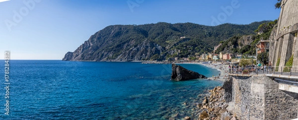 Obraz Monterosso al Mare beach seen from above, with its turquoise sea, rows of umbrellas, and colorful houses typical of the Ligurian coast. Sunny day with Mediterranean light. Cinque Terre, Italy