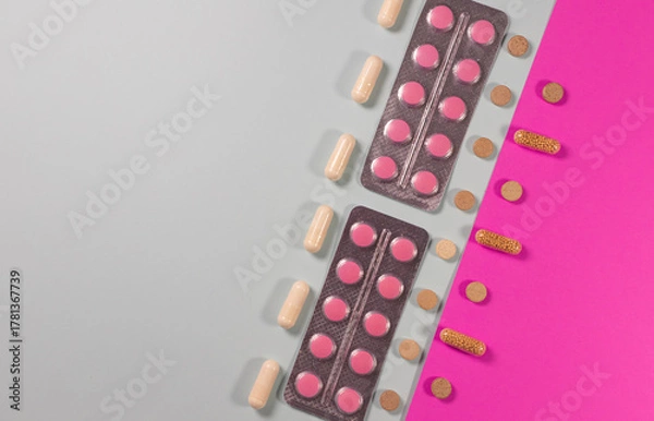 Obraz pills, capsules, and tablets arranged diagonally on a pink and gray background. Concept of medicine, healthcare, pharmacy, vitamins, and modern treatment