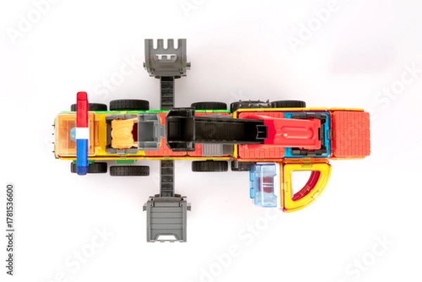 Fototapeta Overhead View of Vibrant Magnetic Toy Crane Truck Assembled with Colorful Blocks
