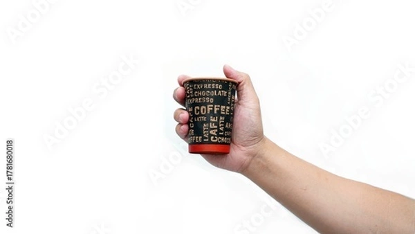 Fototapeta Isolated hand holding paper coffee cup with black lid. Enjoying takeaway coffee with stylish cup