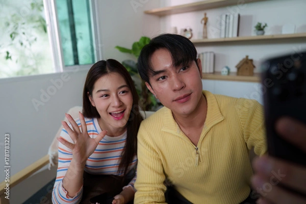 Fototapeta Friendly Interaction. Young couple capturing a selfie while enjoying time together.