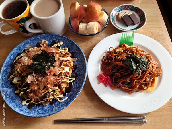Fototapeta Mixed modern (okonomiyaki and sauce yakisoba set meal) served at a local diner, with a small dessert dish / 町の大衆食堂で食べるミックスモダン(お好み焼きとソース焼きそばの定食セット)，デザート小鉢付き