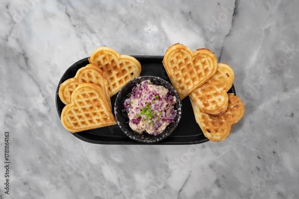 Fototapeta Heart-shaped waffles and a bowl of salad, perfect for a cozy morning breakfast or a romantic treat