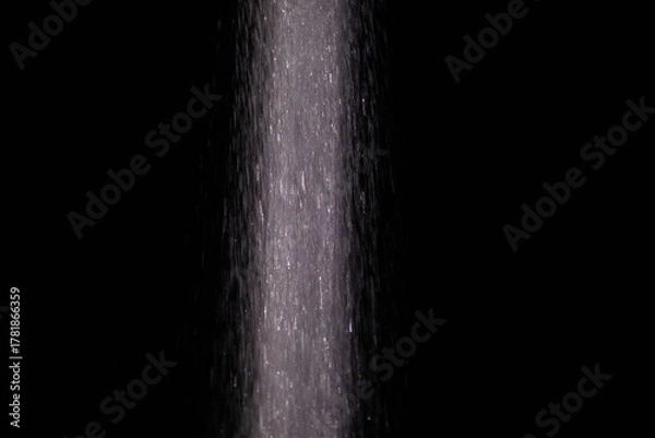 Fototapeta Shimmering water stream dark background