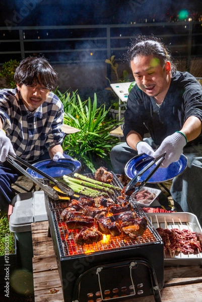 Obraz スペアリブのバーベキューをベランダで楽しむ男性