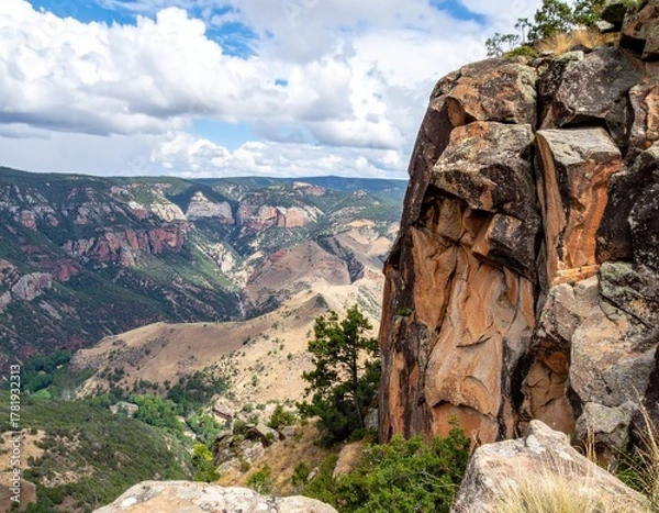 Obraz Steep rocky cliff overlooking deep valley showing rugged natural terrain