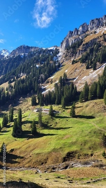 Fototapeta A beautiful mountain scene in the Bernese Oberland, Switzerland, showing a clear view of an impressive mountain range illuminated by warm autumn light