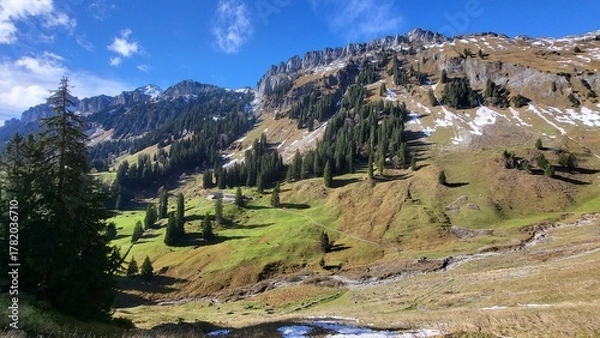 Fototapeta A beautiful mountain scene in the Bernese Oberland, Switzerland, showing a clear view of an impressive mountain range illuminated by warm autumn light