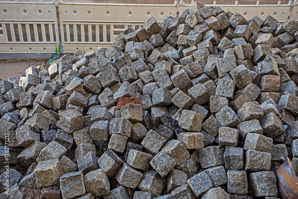 Fototapeta Stone burshtka piled up before a sidewalk resurfacing in the city.