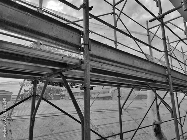 Fototapeta Rome, Italy - October 8, 2025, detail of scaffolding, a temporary structure used in construction and maintenance to allow workers to work safely and access construction sites at height.