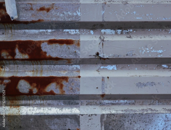Fototapeta A compelling, high-resolution photograph capturing the textured surface of old, corrugated metal. The horizontal ridges of the metal create a linear pattern, emphasizing the grungy and industrial