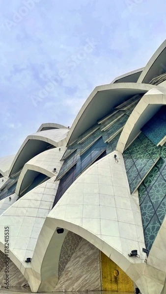 Obraz Contemporary mosque facade with geometric marble panels and reflective glass design. A stunning example of modern Islamic architecture and cultural artistry.