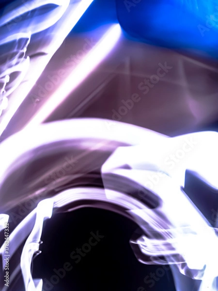 Fototapeta Colorful, fluorescent swirls of light create a dynamic and energetic abstract composition. Blurred streaks of purple, blue, and gold give the impression of rapid, surreal movement.