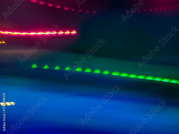 Fototapeta Elegant neon colored lines of light cut through the darkness of the night, giving a futuristic and dynamic impression of speed and movement, like a stunning digital abstract painting