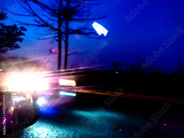 Obraz The glossy, reflective surface reflects intense light with a spectrum of bright colors such as purple, orange, and green, creating a dynamic and surreal abstract scene.