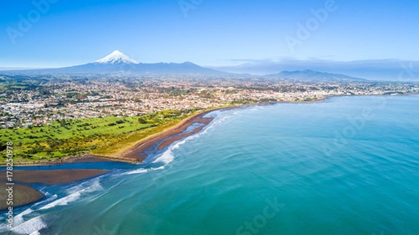 Fototapeta Aerial view on Taranaki coastline with a small river and New Plymouth and Mount Taranaki on the background. Taranaki region, New Zealand