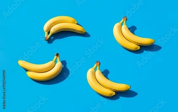 Fototapeta Ripe Yellow Bananas on Bright Blue Background Pattern Flat Lay