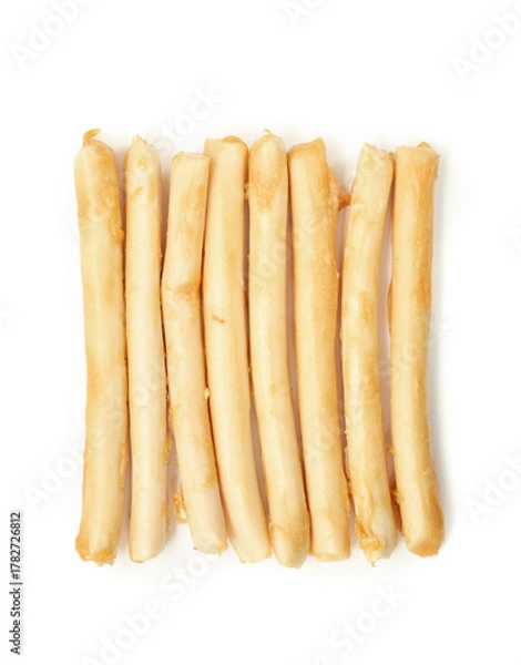 Fototapeta Isolated chew sticks in a row for dogs or cats as treat or reward. Rawhide alternative for dog and cat dental health and enrichment snack. Pile of rolled sticks made of chicken. Selective focus.