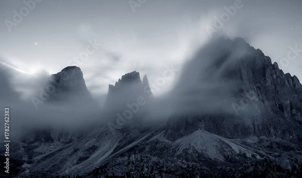 Fototapeta View of the Langkofel group embraced by clouds at sunset in South Tyrol, Italy.