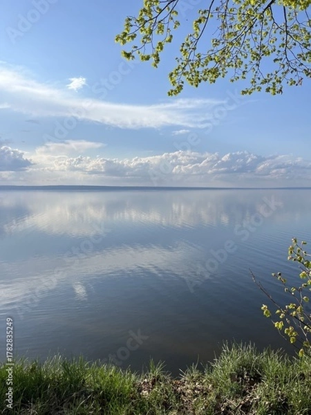 Obraz Wide expanses of the Volga River: the sky is reflected in the quiet surface of the water, view from the green forest. Volga region, Ulyanovsk, Russia.