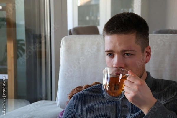 Fototapeta man drinking cup of tea on couch