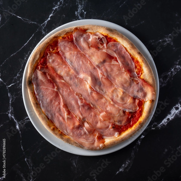 Obraz top view pizza with speck slices on black marble background