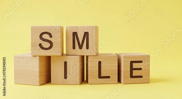 Fototapeta Wooden blocks spelling the word smile on a yellow background concept